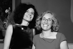 Ema and Marianna smiling at the camera at a gala dinner in late 2025